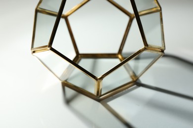 Photo of Stylish golden decor casting beautiful shadows on white table, closeup