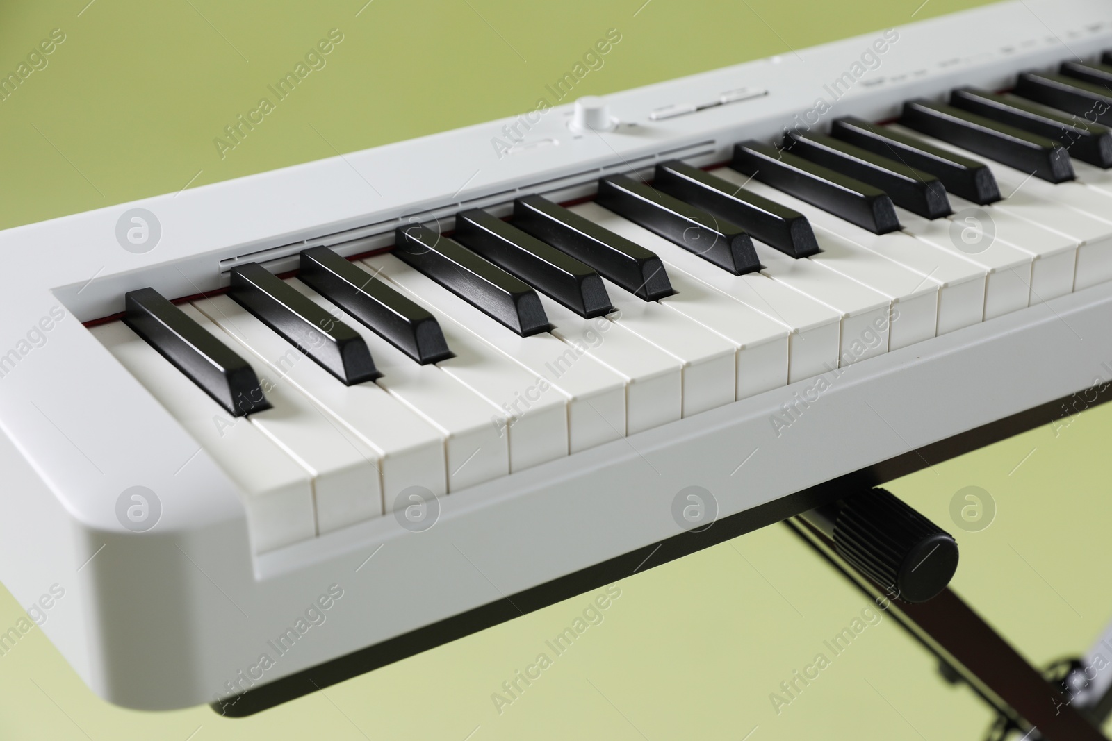 Photo of Synthesizer on green background, closeup. Electronic musical instrument