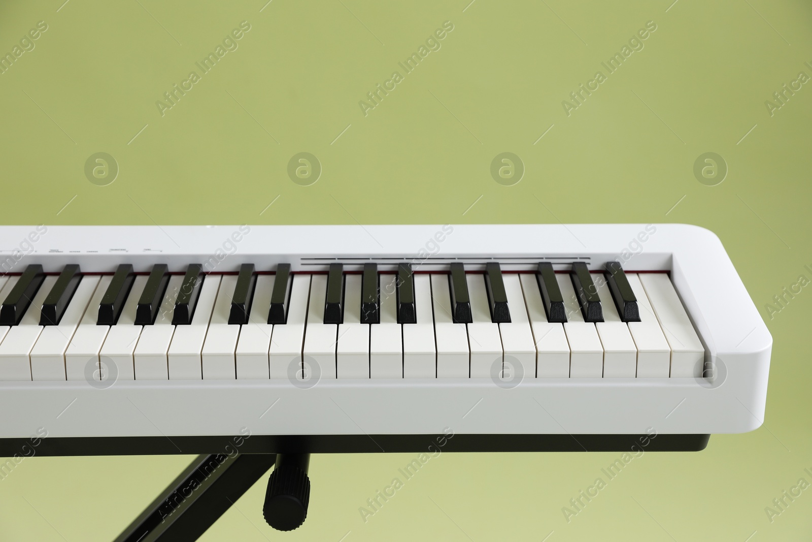 Photo of Synthesizer on green background, closeup. Electronic musical instrument