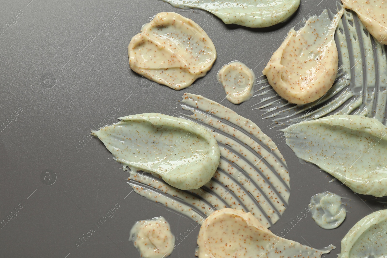 Photo of Samples of body scrubs on grey background, flat lay