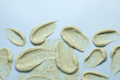 Photo of Smears of body scrub on light background, flat lay