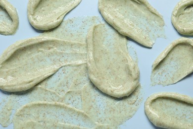 Photo of Smears of body scrub on light background, flat lay