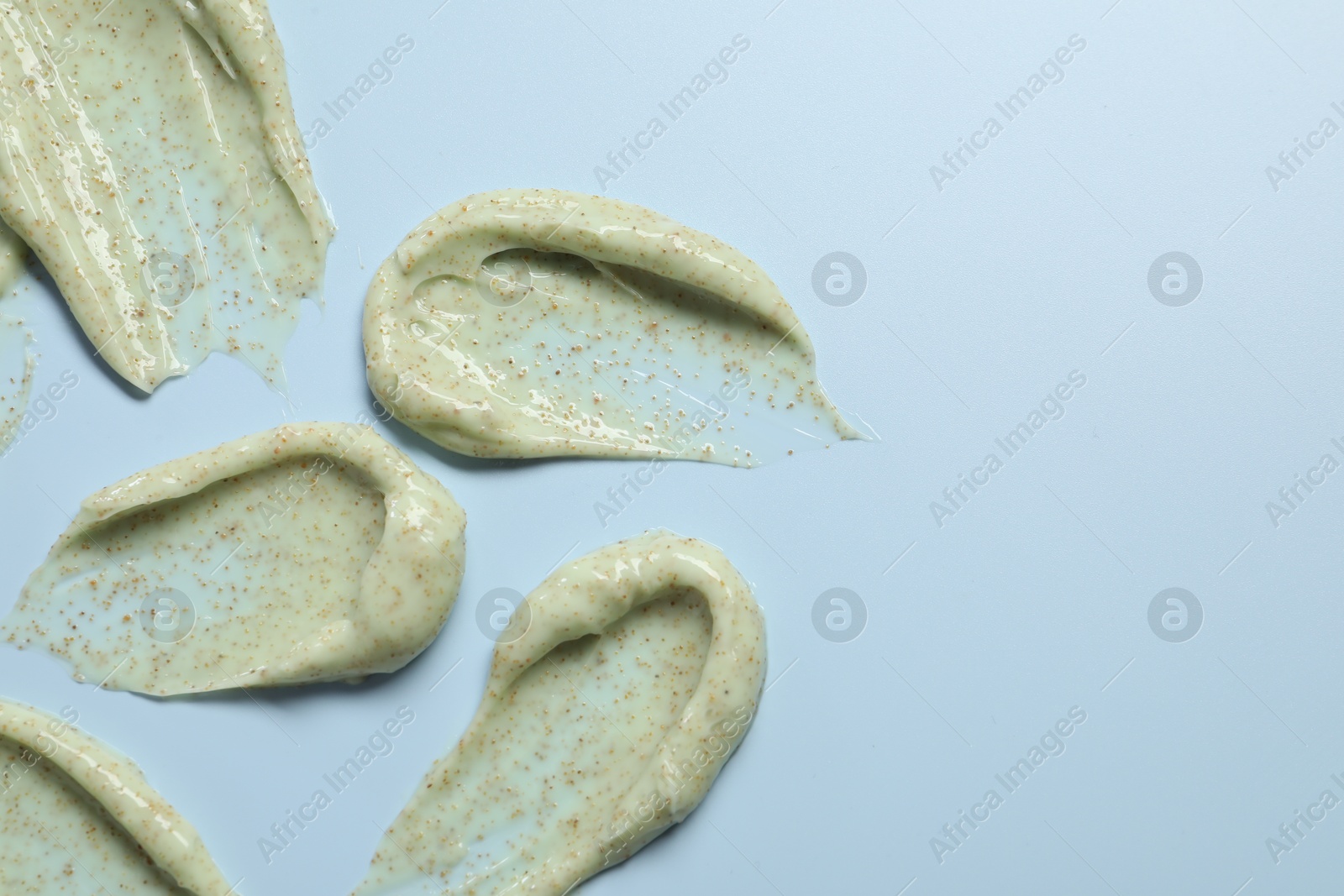 Photo of Smears of body scrub on light background, flat lay. Space for text