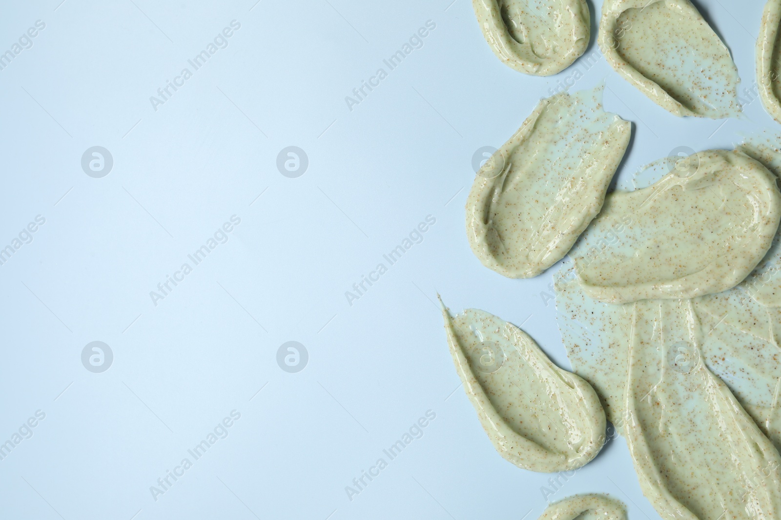 Photo of Smears of body scrub on light background, flat lay. Space for text