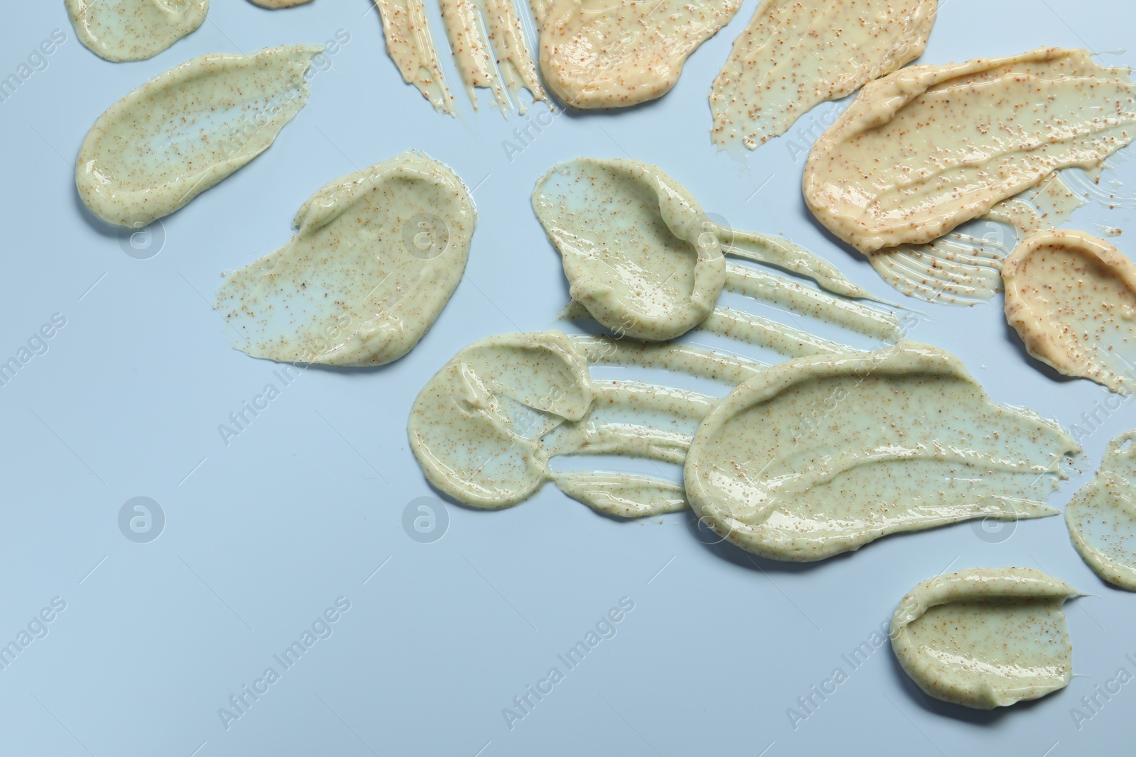 Photo of Samples of body scrubs on light background, flat lay