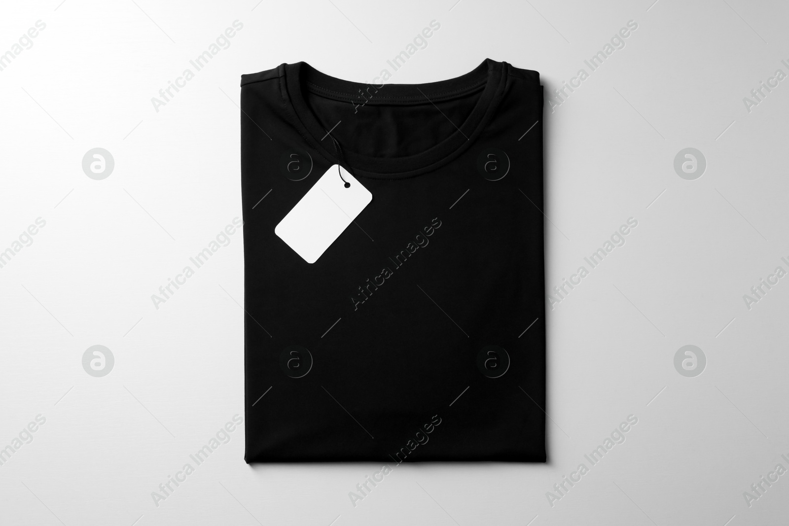 Photo of Blank black t-shirt on white background, top view. Mockup for design