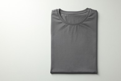 Photo of Blank grey t-shirt on white background, top view. Mockup for design