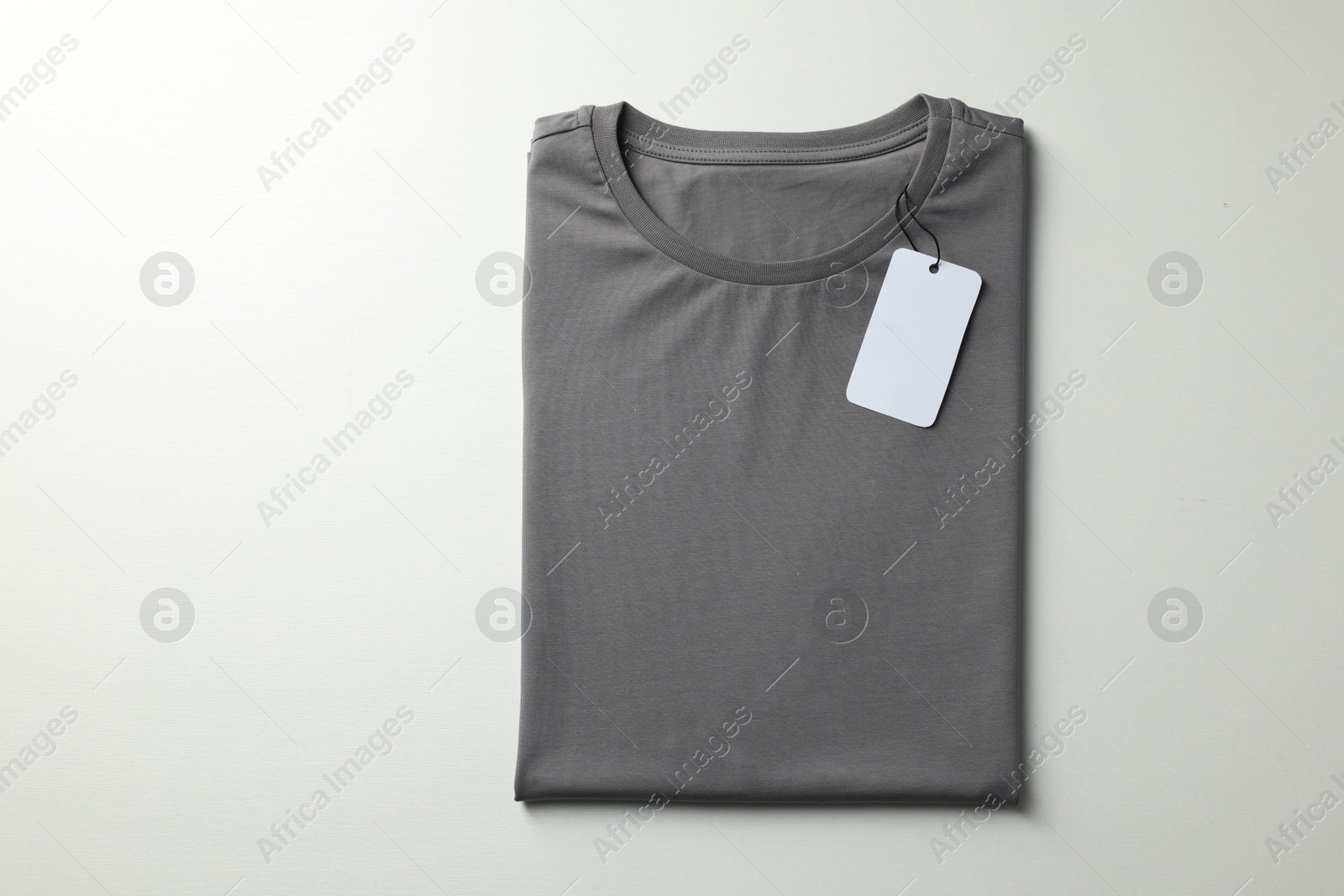 Photo of Blank grey t-shirt on white background, top view. Mockup for design