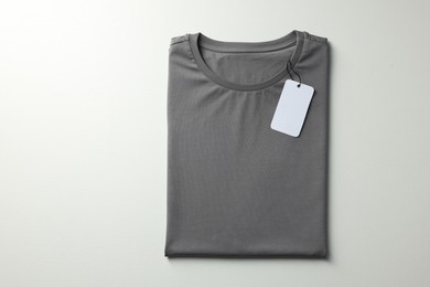 Photo of Blank grey t-shirt on white background, top view. Mockup for design