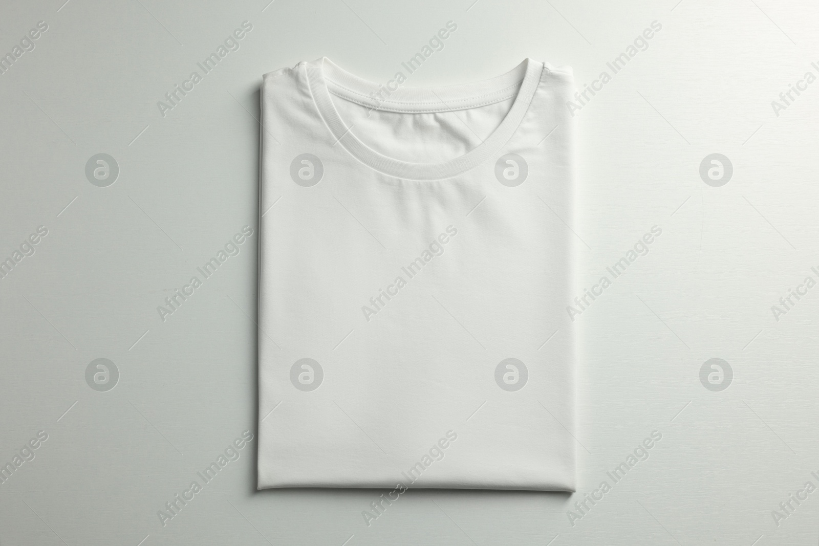 Photo of Blank t-shirt on white background, top view. Mockup for design