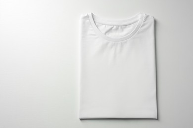 Photo of Blank t-shirt on white background, top view. Mockup for design