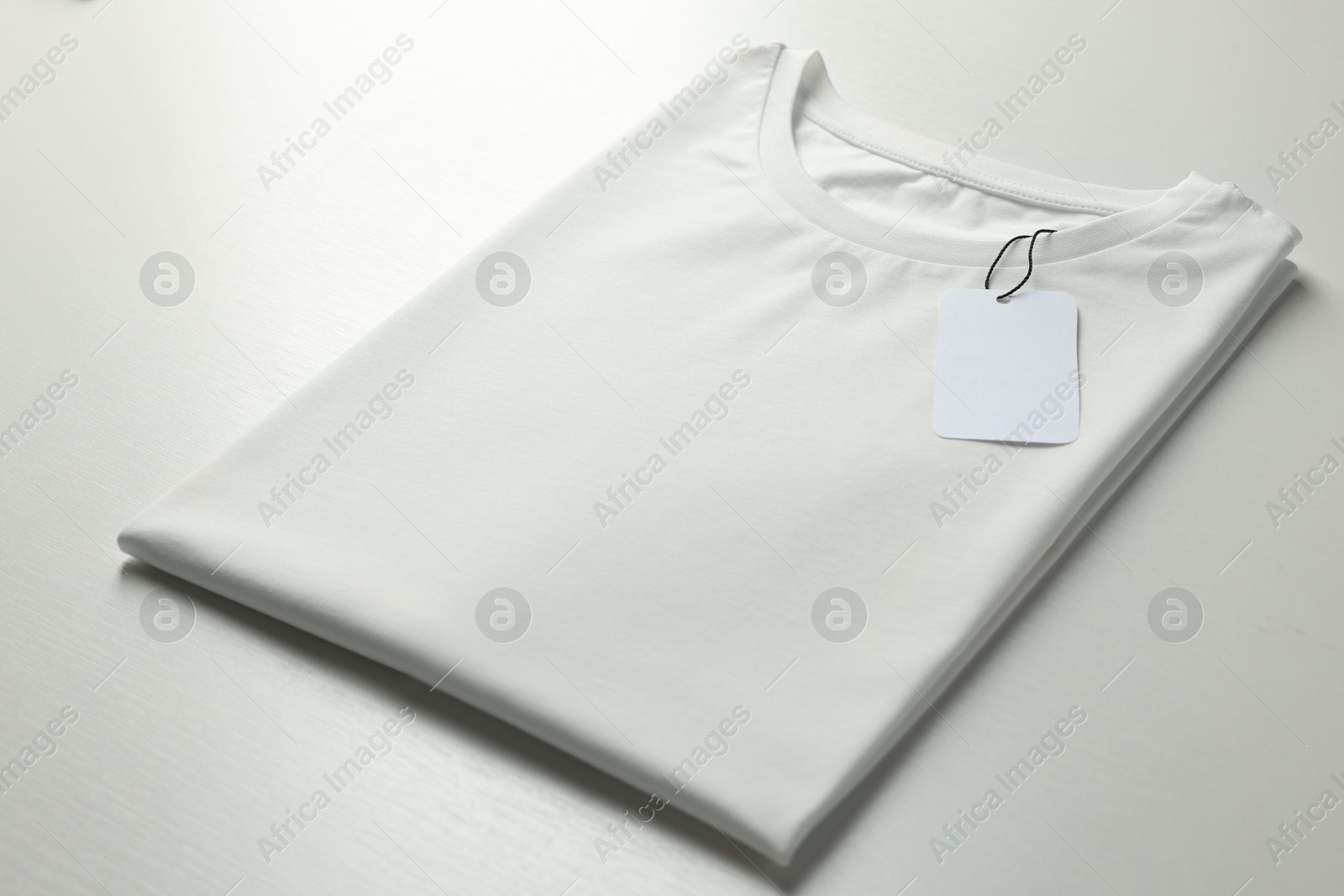 Photo of Blank t-shirt on white background, closeup. Mockup for design