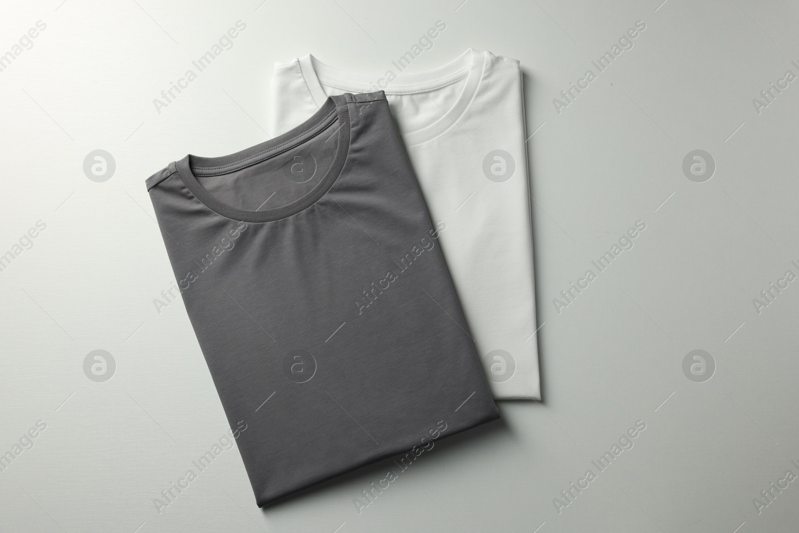 Photo of Different blank t-shirts on white background, top view. Mockup for design