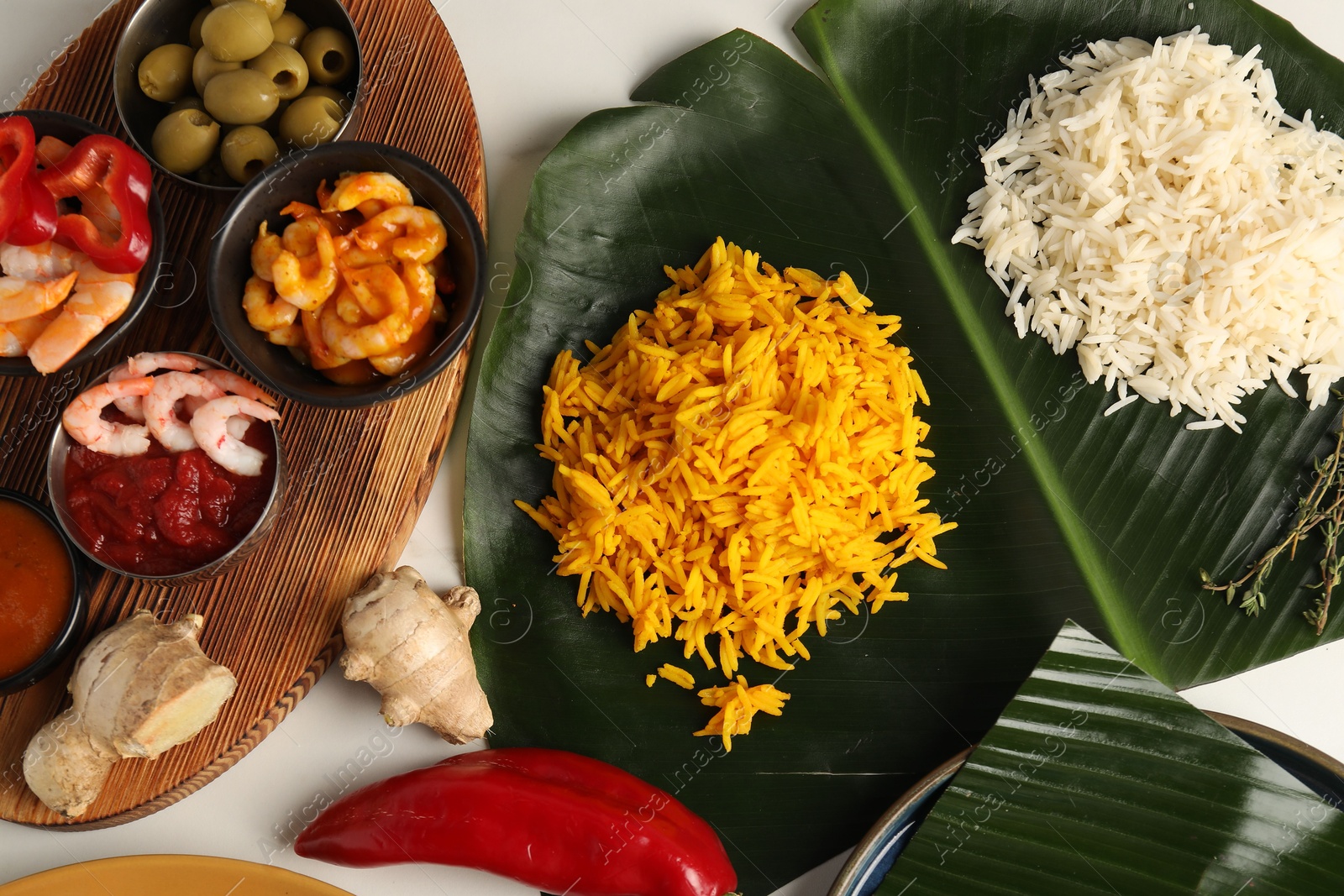 Photo of Cut banana leaf with different food on white table, flat lay. Healthy eco serving