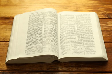 Open Holy Bible in English language on wooden table, closeup