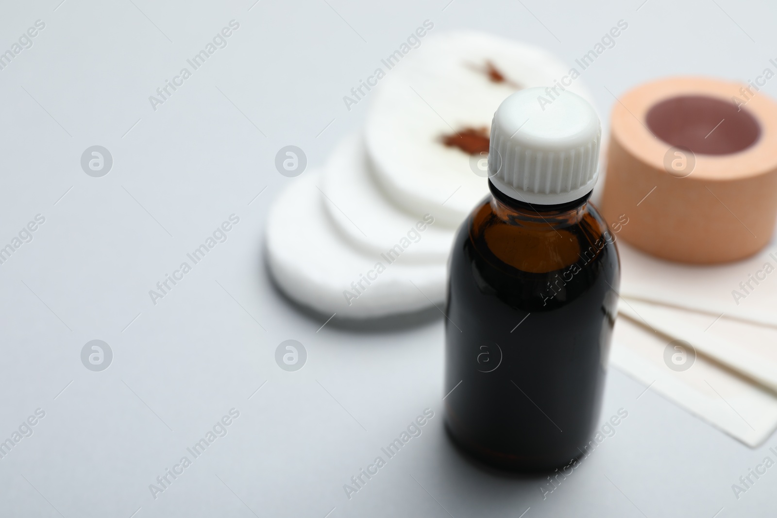 Photo of Topical iodine and other first aid kit components on light grey background, closeup. Space for text