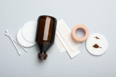 Photo of Topical iodine and other first aid kit components on light grey background, flat lay