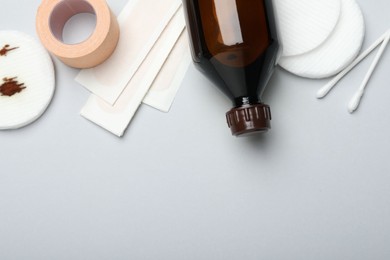 Photo of Topical iodine and other first aid kit components on light grey background, flat lay. Space for text