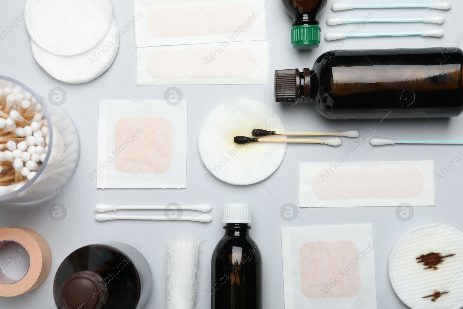 Photo of Topical iodine and other first aid kit components on light grey background, flat lay