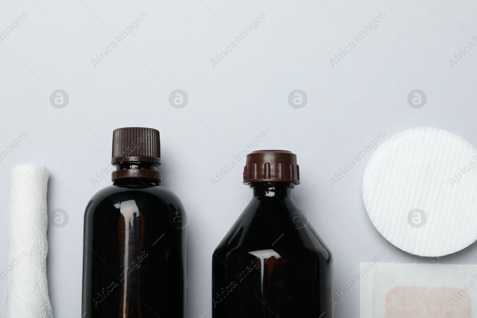 Photo of Topical iodine and other first aid kit components on light grey background, flat lay. Space for text