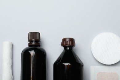 Photo of Topical iodine and other first aid kit components on light grey background, flat lay. Space for text