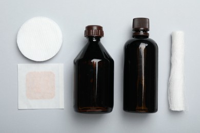 Photo of Topical iodine and other first aid kit components on light grey background, flat lay