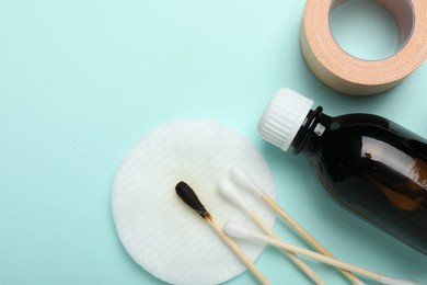 Photo of Topical iodine and other first aid kit components on light blue background, flat lay. Space for text