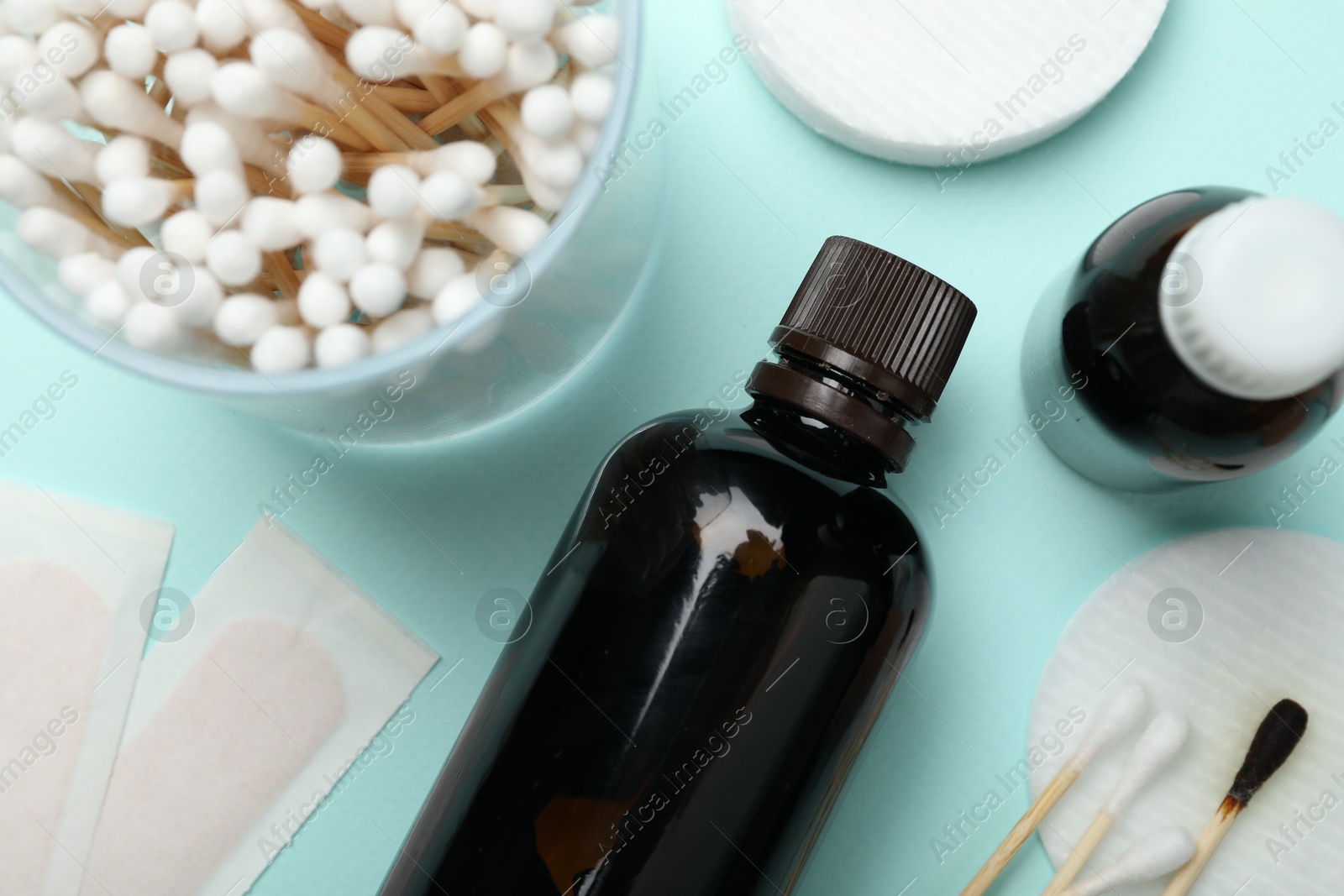 Photo of Topical iodine and other first aid kit components on light blue background, flat lay