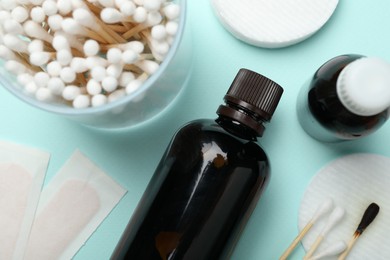 Photo of Topical iodine and other first aid kit components on light blue background, flat lay