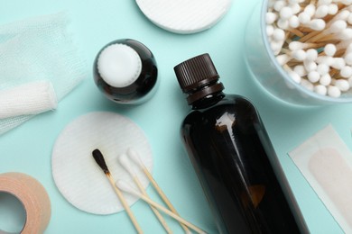 Photo of Topical iodine and other first aid kit components on light blue background, flat lay