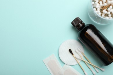 Photo of Topical iodine and other first aid kit components on light blue background, flat lay. Space for text