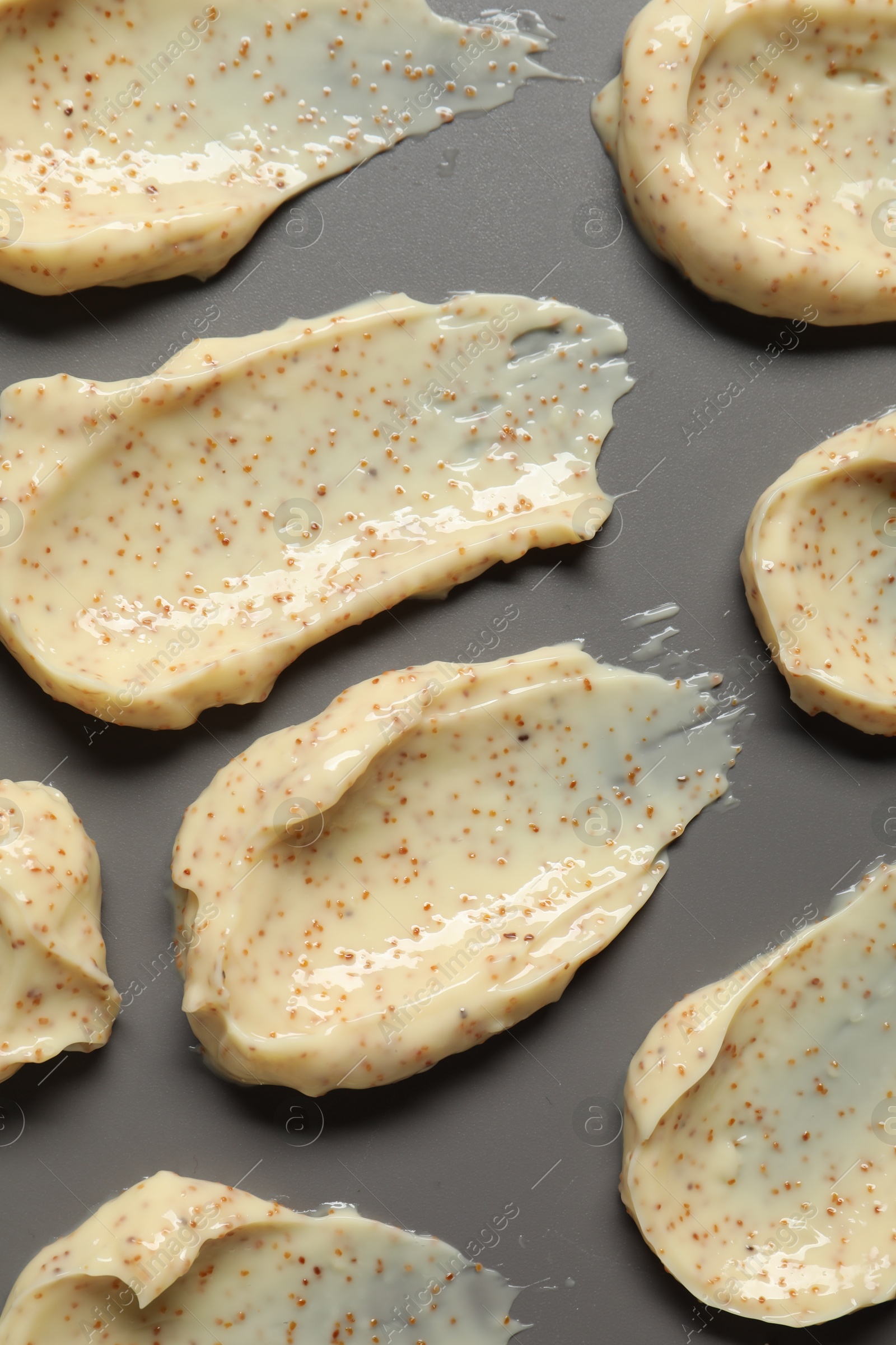 Photo of Smears of body scrub on grey background, flat lay