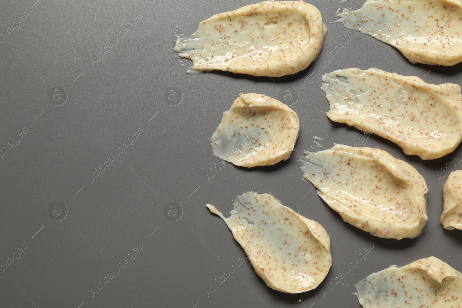 Photo of Smears of body scrub on grey background, flat lay. Space for text