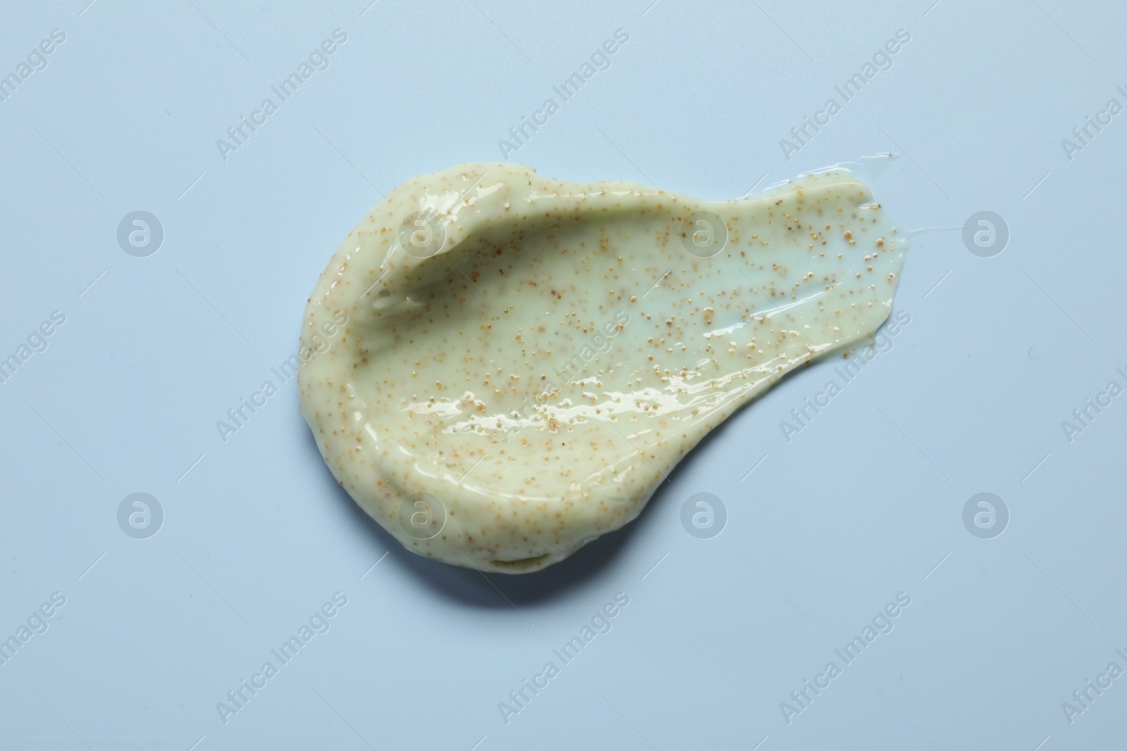 Photo of Smear of body scrub on light background, top view