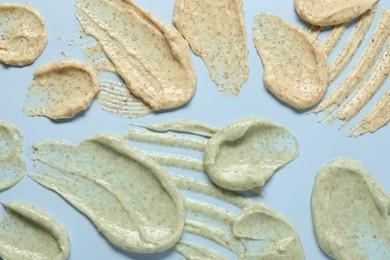 Photo of Samples of body scrubs on light background, flat lay