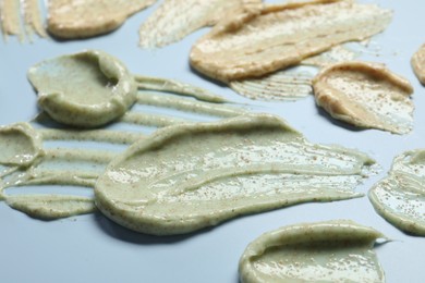 Photo of Samples of body scrubs on light background, closeup