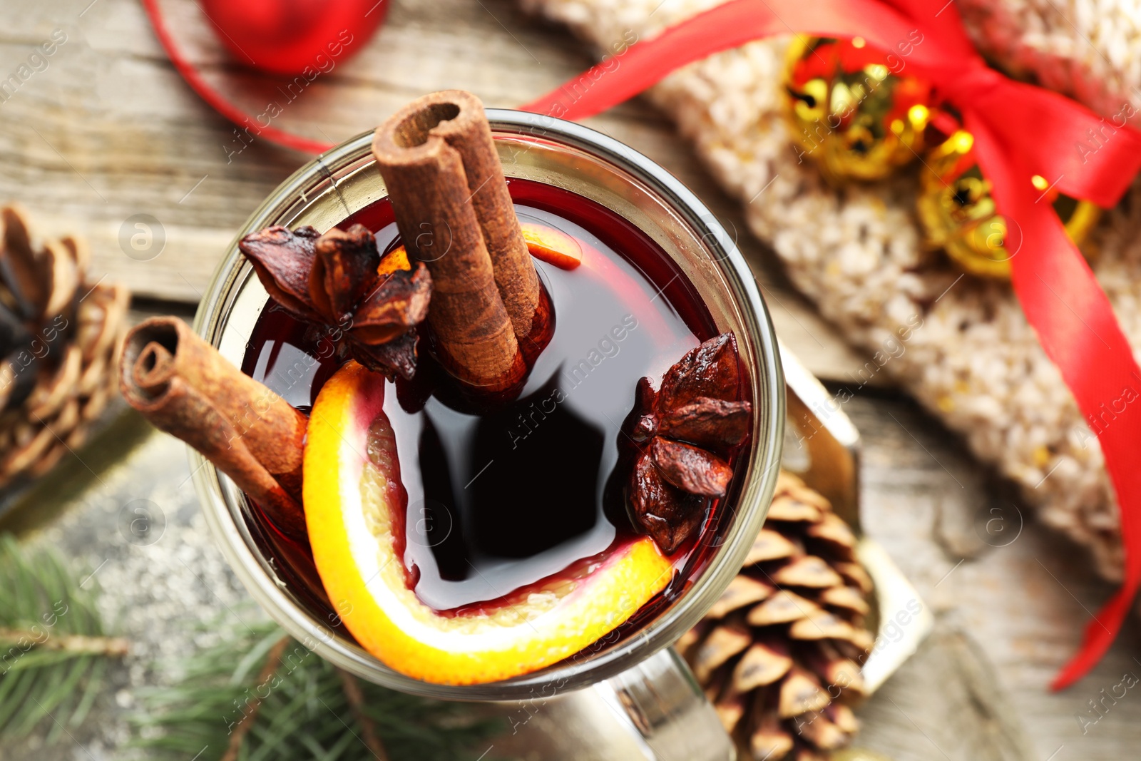 Photo of Tasty mulled wine with spices and Christmas decor on table, top view