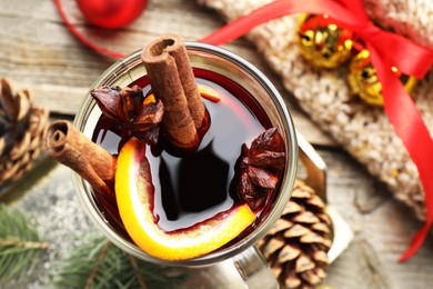 Photo of Tasty mulled wine with spices and Christmas decor on table, top view