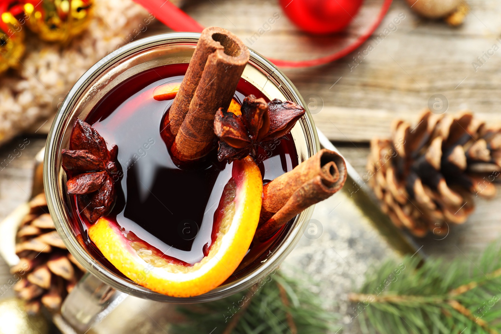 Photo of Tasty mulled wine with spices and Christmas decor on table, top view