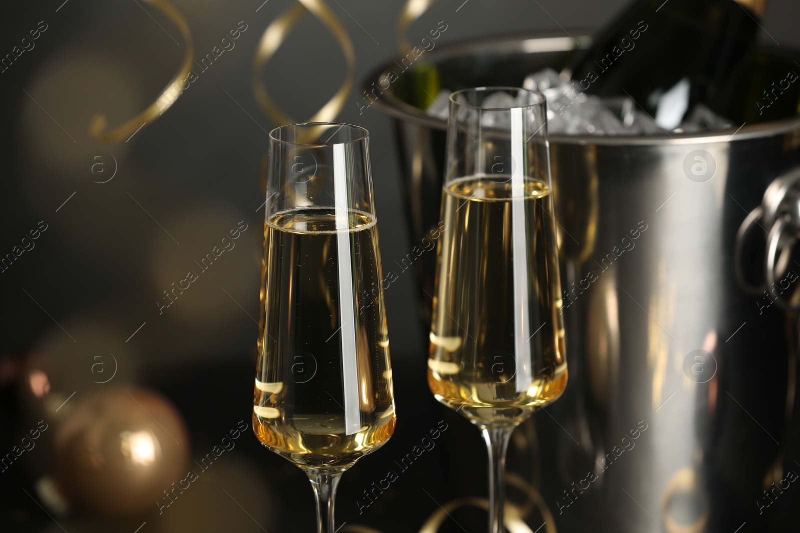 Photo of Champagne in glasses and decor on dark background, closeup. Christmas celebration