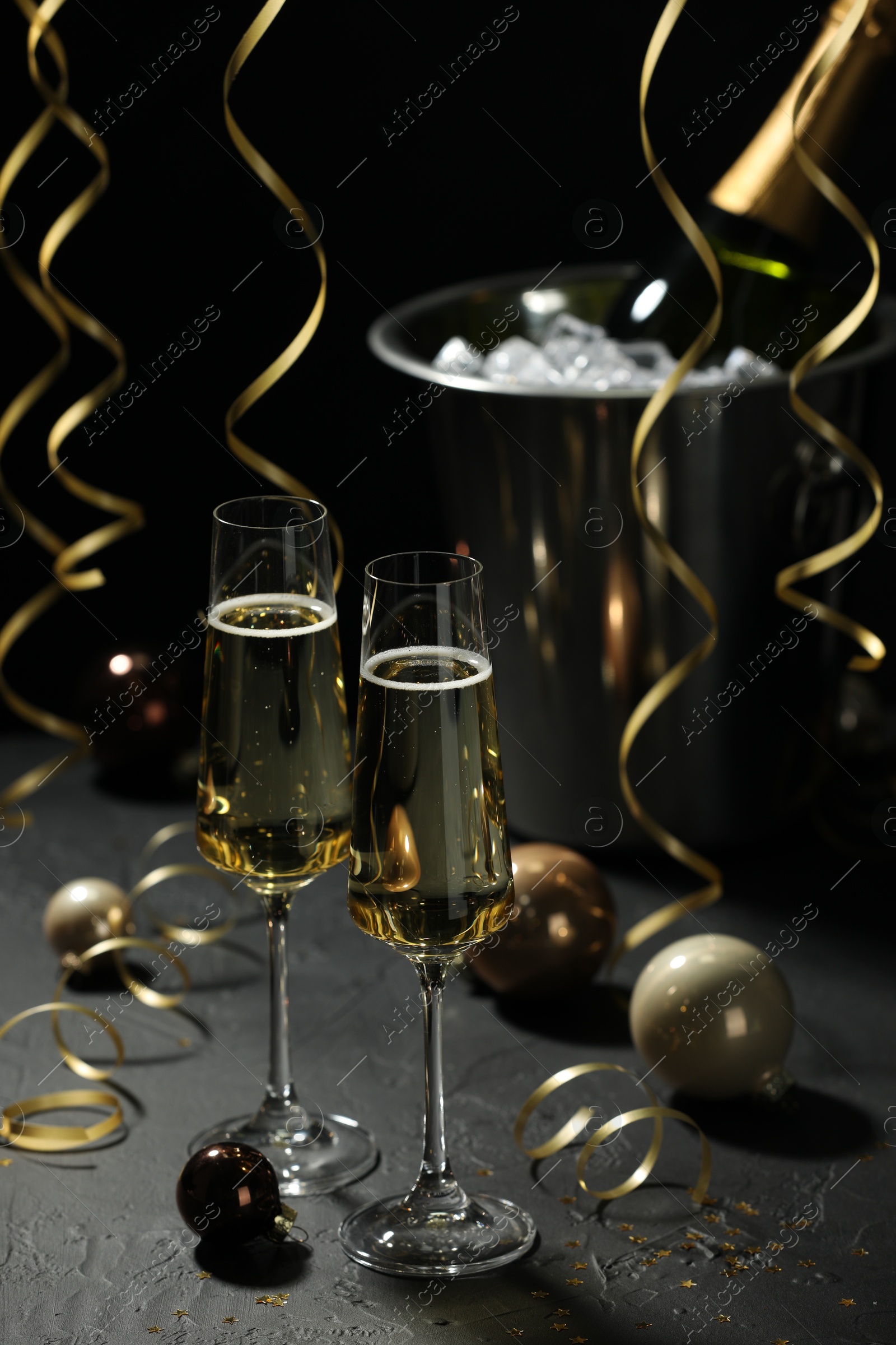 Photo of Champagne in glasses and decor on grey table. Christmas celebration