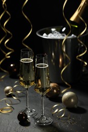 Photo of Champagne in glasses and decor on grey table. Christmas celebration