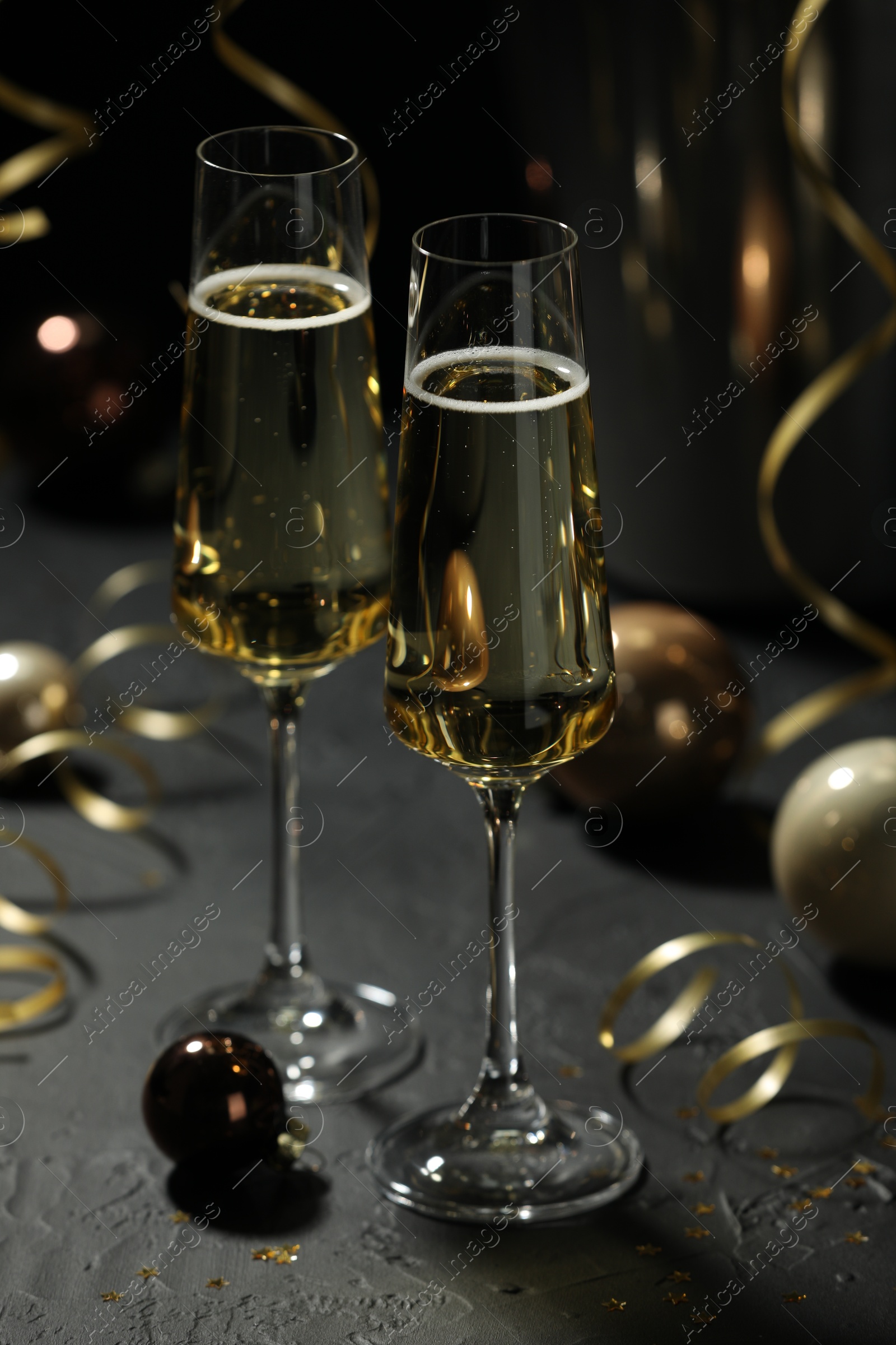 Photo of Champagne in glasses and decor on grey table. Christmas celebration