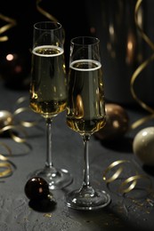 Photo of Champagne in glasses and decor on grey table. Christmas celebration