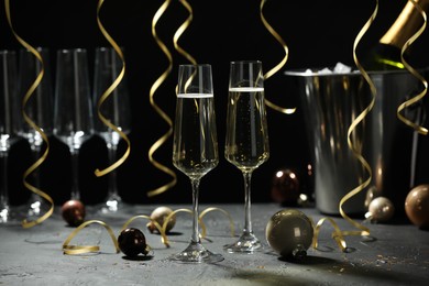 Photo of Champagne in glasses and decor on grey table. Christmas celebration