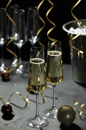 Photo of Champagne in glasses and decor on grey table. Christmas celebration