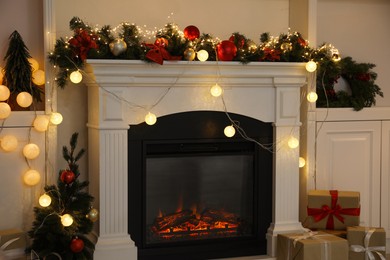 Photo of Stylish fireplace with Christmas decor and presents in cozy room