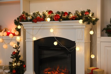 Photo of Stylish fireplace with Christmas decor in cozy room