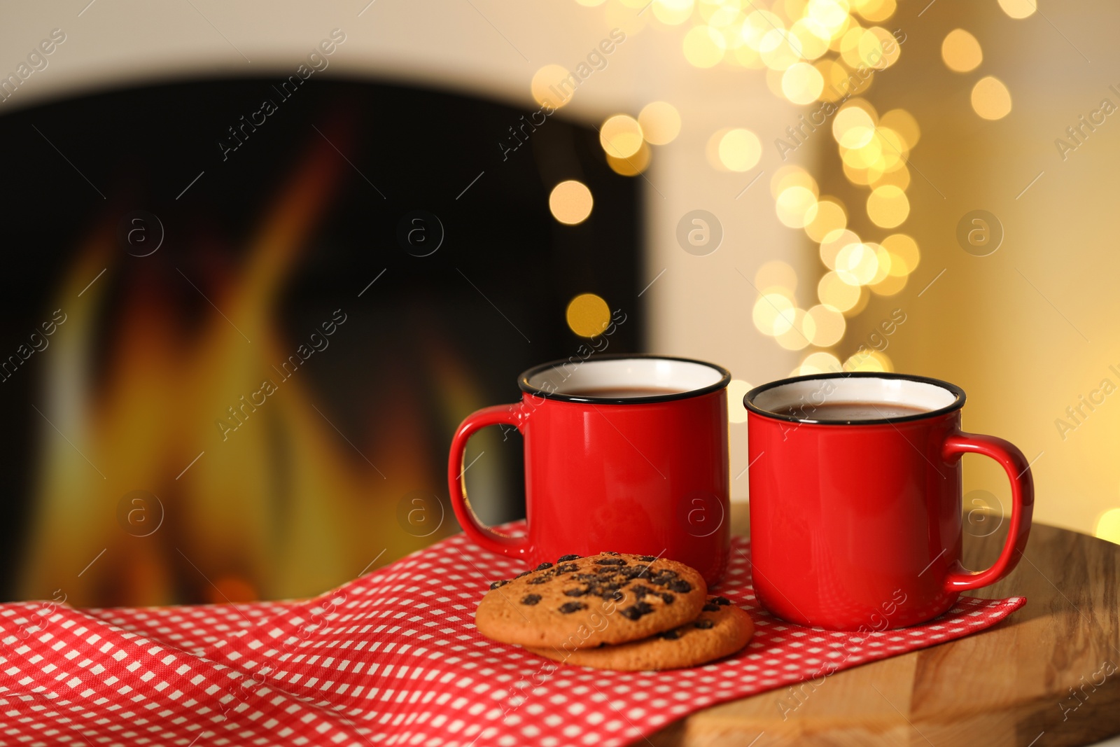 Photo of Tasty cocoa in cups and chocolate chip cookies on table against blurred Christmas lights, bokeh effect. Space for text