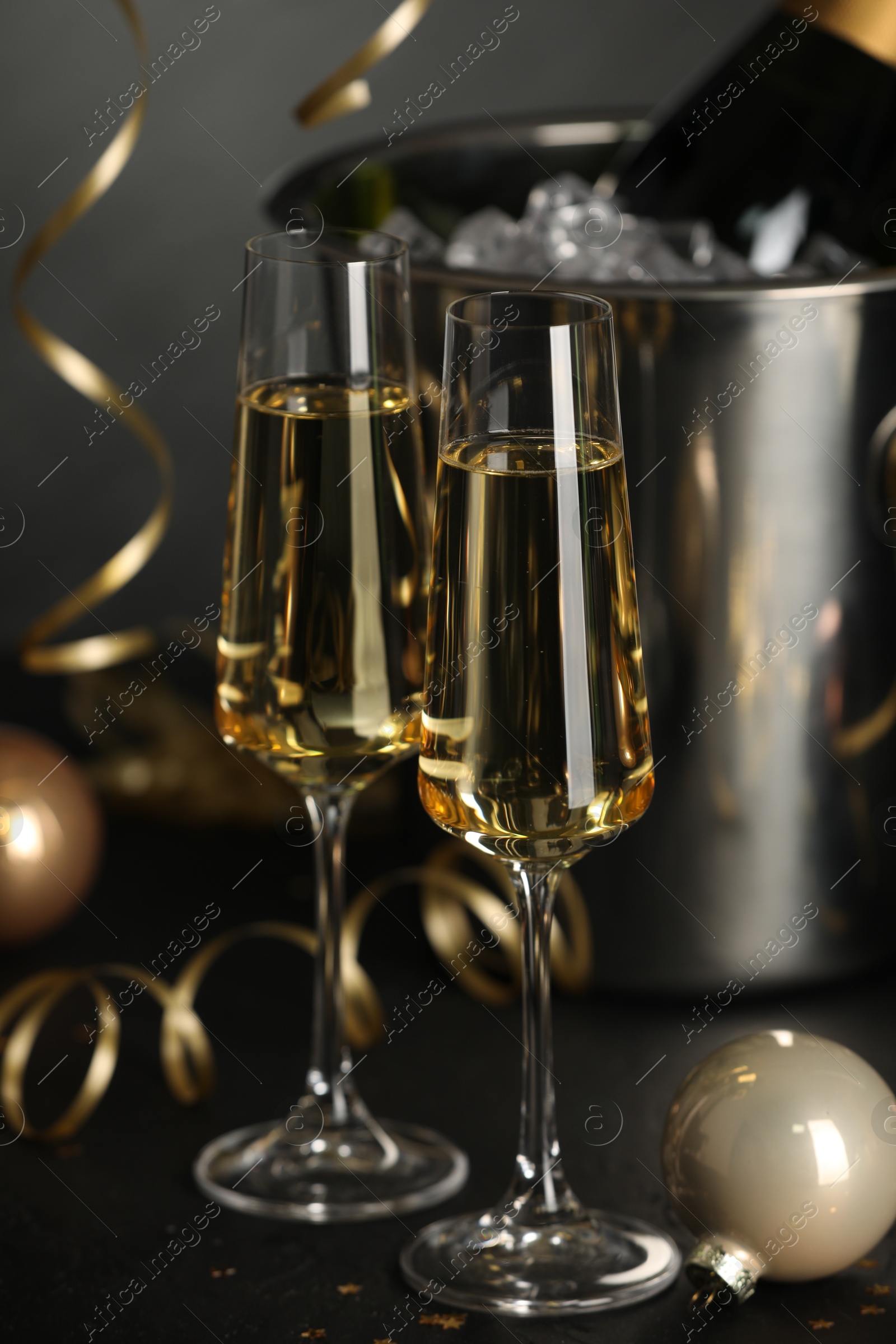 Photo of Champagne in glasses and decor on black table. Christmas celebration